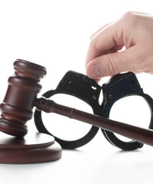 criminal news. a judicial hammer and handcuffs on a white background.